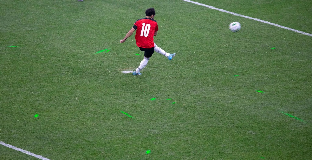 Das Licht ist von den grünen Laserpointern auf dem Spielfeld zu sehen, wenn Mohamed Salah den Ball während eines Elfmeterschießens tritt