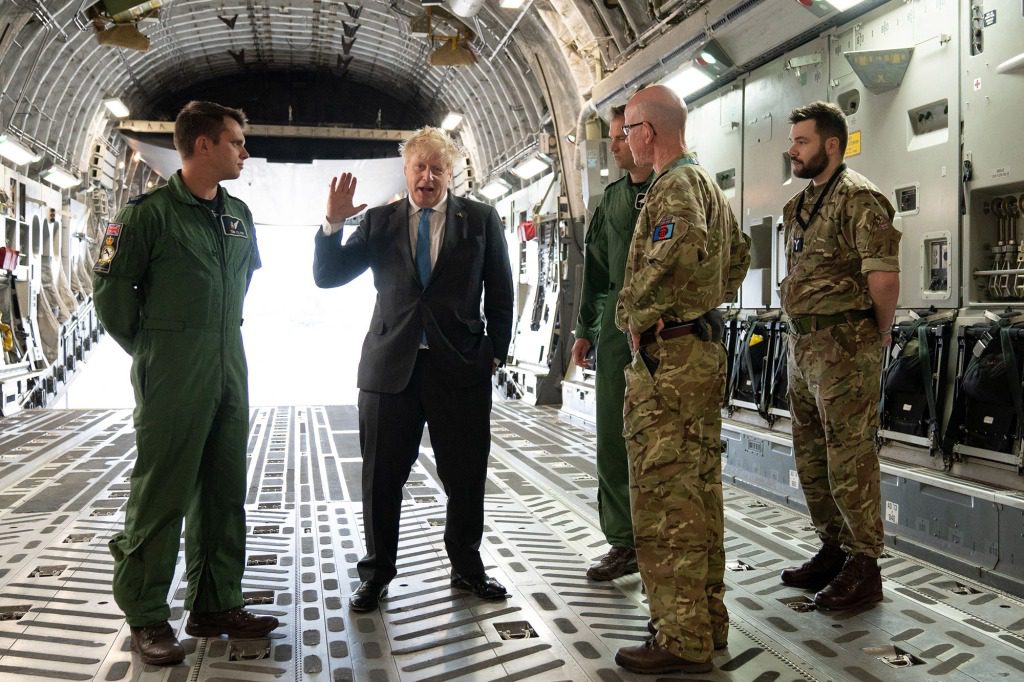 Boris Johnson spricht mit Air Loadmaster 99 Squadron Sergeant Tom Clare, Officer Commanding 99th Squadron Wing Commander Will Essex und Officer Commanding Operations Wing of RAF Brize Norton Wing Commander Andy Hampshire nach seiner Rückkehr aus Kiew.