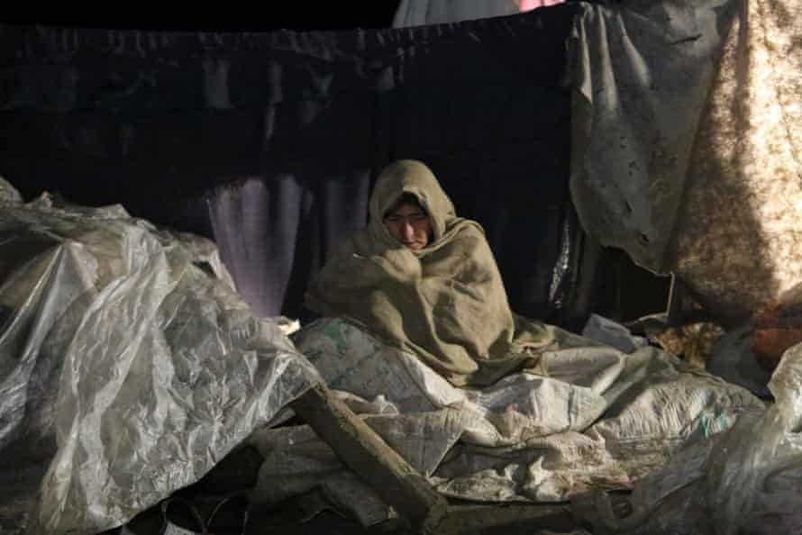 Eine Frau im Bundesstaat Paktika, die durch das Erdbeben obdachlos geworden ist, versucht, sich warm zu halten.